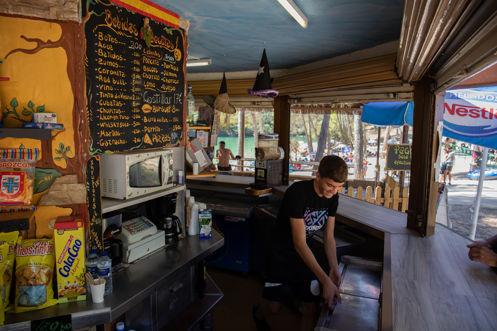 Un camarero trabajando en el kiosko de comida y bebida del embalse de Bolarque, en Guadalajara (Castilla La-Mancha).