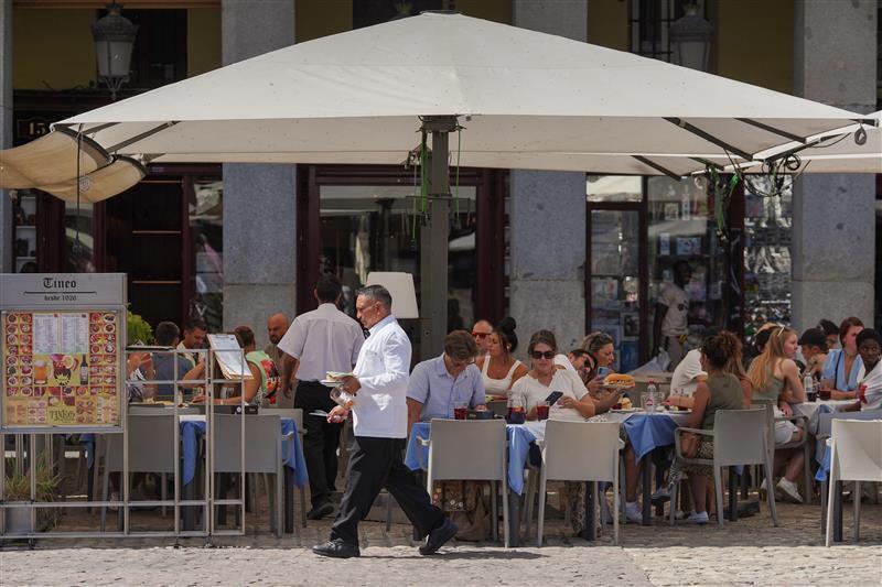 Camareros atienden a clientes en la Plaza Mayor de Madrid.