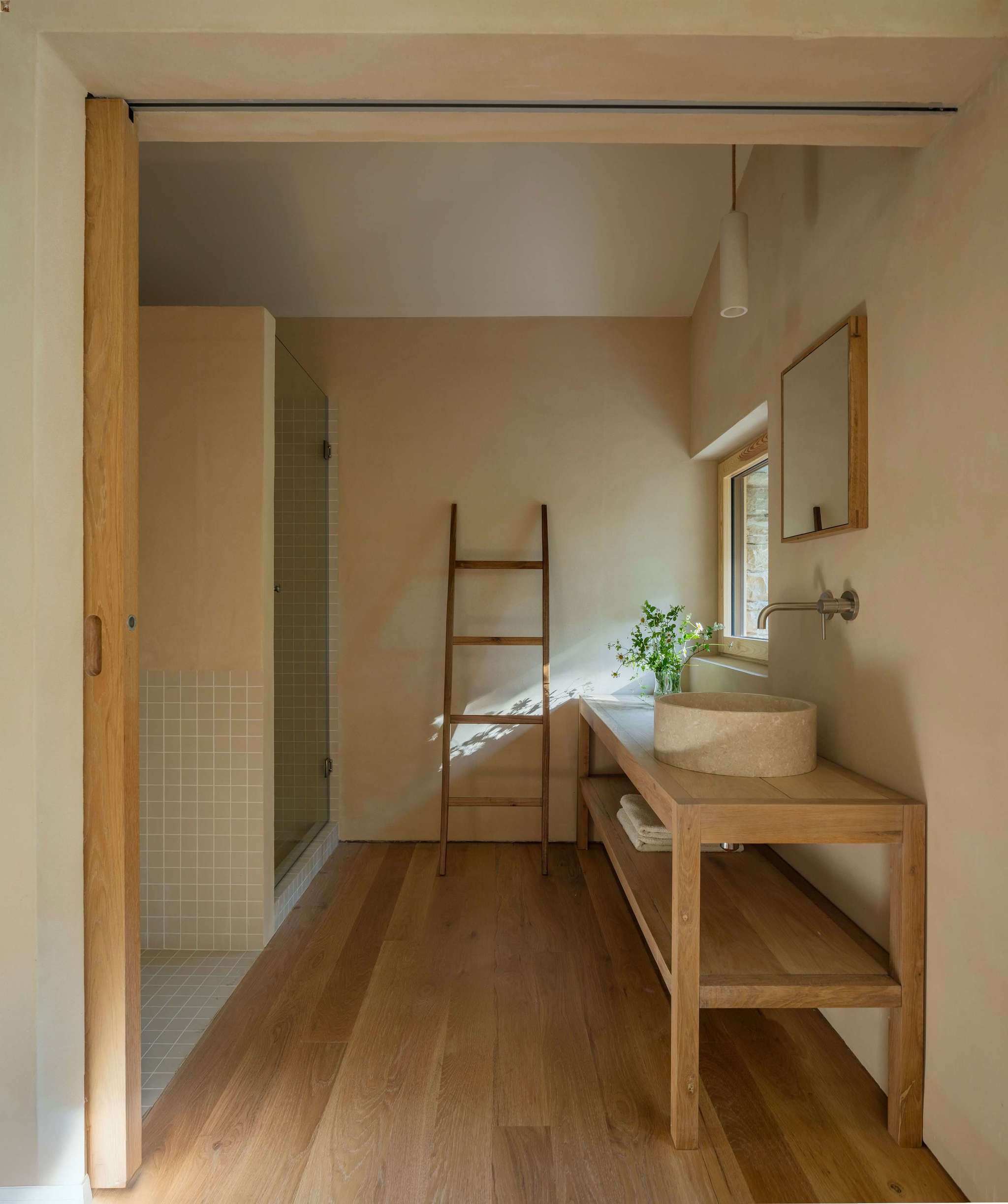 En el baño se aprecia el uso de materiales naturales y de proximidad: mortero de cal, madera de roble, piedra original y cerámica.